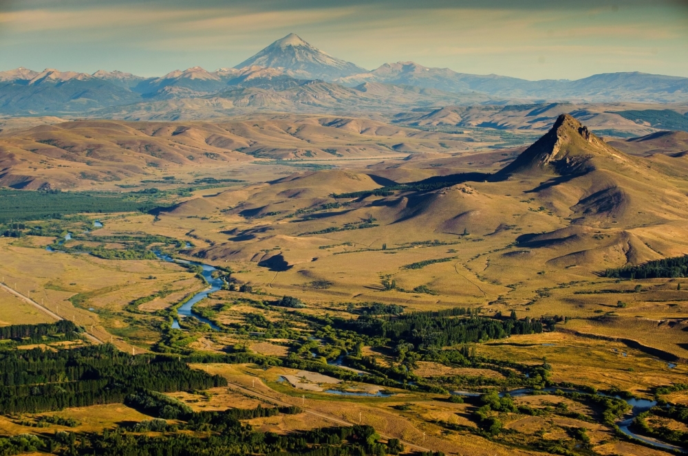 Tipiliuke mountain and the Chimehuín river by Eliseo Miciu, featuring Lanín volcano in the background